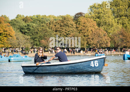 Una coppia in una barca a remi sulla serpentina in London Hyde Park, London, Regno Unito Foto Stock