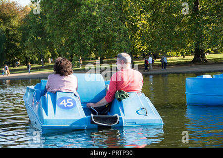 Un marito e una moglie su un pedalò sulla serpentina in London Hyde Park, London, Regno Unito Foto Stock