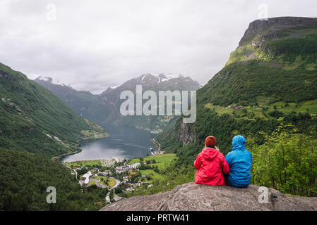 Città di Geiranger e il Geirangerfjord fiordo, Norvegia. Accoppiare i viaggiatori Foto Stock