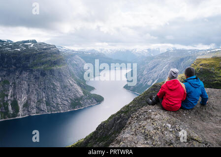 Ringedalsvatnet lago vicino Trolltunga. Uno di Norvegia la maggior parte vista spettacolare. Accoppiare i viaggiatori si siede sulla roccia e gode di una splendida vista Foto Stock