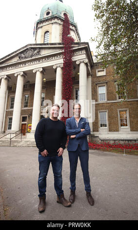 Solo uso editoriale artista Paul Cummins (sinistra) e il designer Tom Piper accanto a loro scultura di papavero piangendo finestra, dopo quattro anni di tour del Regno Unito si aprirà venerdì 5 ottobre presso l'Imperial War Museum di Londra. Foto Stock