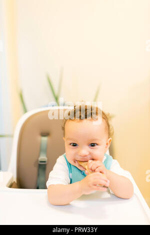 Sorridente bambino seduto nel seggiolone Foto Stock