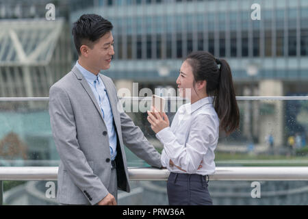 Giovane imprenditrice e uomo che parla in città, Shanghai, Cina Foto Stock