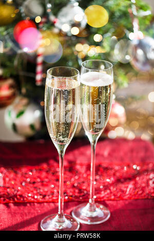 Due flauti Champagne su sfondo di Natale con albero di Natale Foto Stock