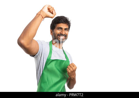 Sorridente maschio indiano ipermercati e supermercati dipendente celebrando con un pugno in alto e uno in basso come concetto di successo isolato su bianco studio backg Foto Stock
