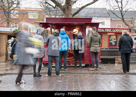 York, Regno Unito - 12 DIC 2016: Natale agli acquirenti di coda per la torta dello Yorkshire e salsiccia al St Nicholas Mercatino di Natale il 12 dicembre presso il St Sampson Square Foto Stock
