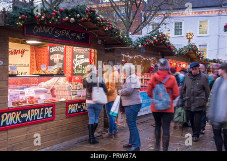 York, Regno Unito - 12 DIC 2016: gli acquirenti a coda di maiale e torta di mele stallo a St Nicholas Mercatino di Natale il 12 dicembre presso il St Sampson Square, York Foto Stock