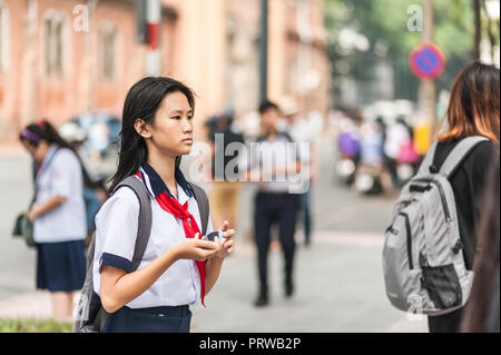 Ho Chi Minh City, Vietman - Ottobre 21, 2016. Studente in un tradizionale uniforme comunista a piedi a Notre Dame de Paris Square. Indossando un rosso pioneer sciarpa. Foto Stock