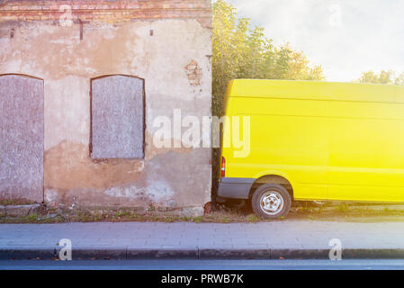 Parcheggiato il giallo per il trasporto di merci in prossimità della parete. Foto Stock