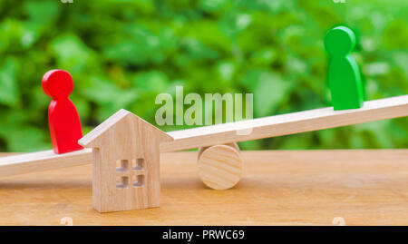 Figure in legno sulla bilancia il chiarimento di proprietà della casa, immobiliari. rivali nell'azienda. concorrenza, corte. Diritto immobiliare concetto. divorc Foto Stock