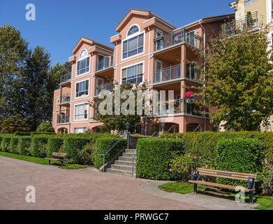 Appartamento Edificio sulla giornata soleggiata con panca e viale lastricato in parte anteriore Foto Stock