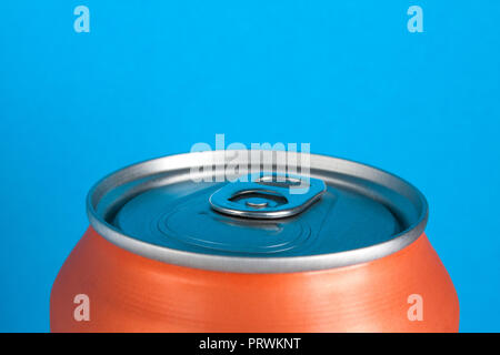 Orange chiuso di alluminio è di soda o di una birra su uno sfondo blu con copyspace Foto Stock