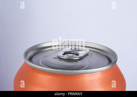 Orange chiuso di alluminio è di soda o di una birra su uno sfondo grigio Foto Stock