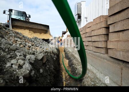 Amtsberg, in Sassonia. 04 ott 2018. Lavoratori edili preparare la posa di cavi a fibre ottiche in un insediamento. Il 04.10.2018 la prima sezione della nuova rete in fibra ottica nel comune di Amtsberg nei Monti Metalliferi è stato messo in funzione. Il totale dei costi della rete di espansione in Amtsberg ammontano a 4,7 milioni di euro. Il Sassone membro del governo e il governo federale di sostenere questo passo verso il futuro con 4,2 milioni di euro. Credito: Sebastian Willnow/dpa-Zentralbild/dpa/Alamy Live News Foto Stock