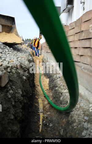 Amtsberg, in Sassonia. 04 ott 2018. Lavoratori edili preparare la posa di cavi a fibre ottiche in un insediamento. Il 04.10.2018 la prima sezione della nuova rete in fibra ottica nel comune di Amtsberg nei Monti Metalliferi è stato messo in funzione. Il totale dei costi della rete di espansione in Amtsberg ammontano a 4,7 milioni di euro. Il Sassone membro del governo e il governo federale di sostenere questo passo verso il futuro con 4,2 milioni di euro. Credito: Sebastian Willnow/dpa-Zentralbild/dpa/Alamy Live News Foto Stock