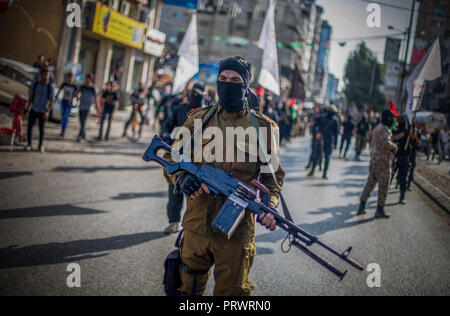 La città di Gaza, Palestina. 4 Ott 2018. Un ufficiale militare visto in possesso di una pistola durante il mese di marzo.I membri del palestinese Brigate Al-Quds, l ala militare della Jihad islamica gruppo di marzo nella città di Gaza con le loro armi per mostrare la fedeltà per l iraniana-backed movimento palestinese recentemente eletto leader Ziad al-Nakhalah. Credito: Mahmoud Issa/SOPA Immagini/ZUMA filo/Alamy Live News Foto Stock