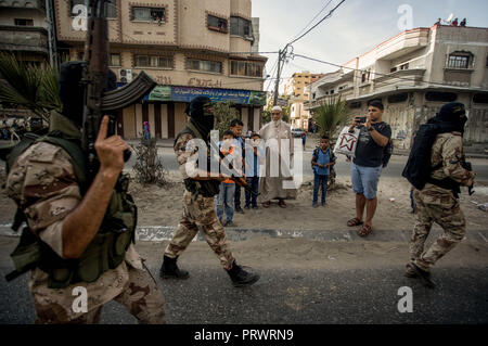 La città di Gaza, Palestina. 4 Ott 2018. Ufficiali militari sono visti camminare tenendo le pistole durante il mese di marzo.I membri del palestinese Brigate Al-Quds, l ala militare della Jihad islamica gruppo di marzo nella città di Gaza con le loro armi per mostrare la fedeltà per l iraniana-backed movimento palestinese recentemente eletto leader Ziad al-Nakhalah. Credito: Mahmoud Issa/SOPA Immagini/ZUMA filo/Alamy Live News Foto Stock