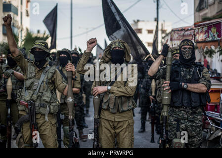 La città di Gaza, Palestina. 4 Ott 2018. Ufficiali militari sono visto in piedi salendo i loro pugni tenendo armi durante il mese di marzo.I membri del palestinese Brigate Al-Quds, l ala militare della Jihad islamica gruppo di marzo nella città di Gaza con le loro armi per mostrare la fedeltà per l iraniana-backed movimento palestinese recentemente eletto leader Ziad al-Nakhalah. Credito: Mahmoud Issa/SOPA Immagini/ZUMA filo/Alamy Live News Foto Stock