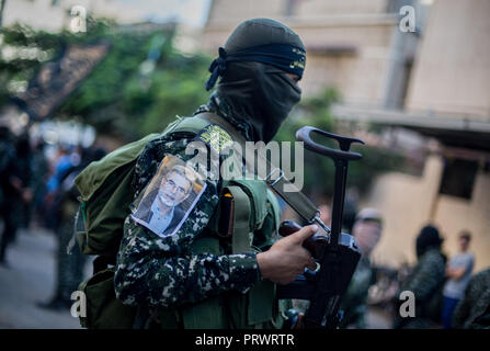 La città di Gaza, Palestina. 4 Ott 2018. Un ufficiale militare visto in possesso di una pistola durante il mese di marzo.I membri del palestinese Brigate Al-Quds, l ala militare della Jihad islamica gruppo di marzo nella città di Gaza con le loro armi per mostrare la fedeltà per l iraniana-backed movimento palestinese recentemente eletto leader Ziad al-Nakhalah. Credito: Mahmoud Issa/SOPA Immagini/ZUMA filo/Alamy Live News Foto Stock