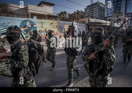 La città di Gaza, Palestina. 4 Ott 2018. Ufficiali militari sono visti camminare tenendo le pistole durante il mese di marzo.I membri del palestinese Brigate Al-Quds, l ala militare della Jihad islamica gruppo di marzo nella città di Gaza con le loro armi per mostrare la fedeltà per l iraniana-backed movimento palestinese recentemente eletto leader Ziad al-Nakhalah. Credito: Mahmoud Issa/SOPA Immagini/ZUMA filo/Alamy Live News Foto Stock