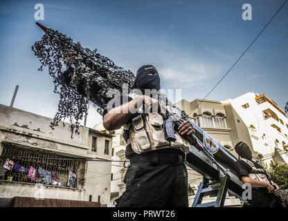 La città di Gaza, Palestina. 4 Ott 2018. Un ufficiale militare visto in piedi di fronte ad un locale Gazan razzo realizzato durante la sfilata.I membri del palestinese Brigate Al-Quds, l ala militare della Jihad islamica gruppo di marzo nella città di Gaza con le loro armi per mostrare la fedeltà per l iraniana-backed movimento palestinese recentemente eletto leader Ziad al-Nakhalah. Credito: Nidal Alwaheidi SOPA/images/ZUMA filo/Alamy Live News Foto Stock