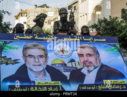 La città di Gaza, Palestina. 4 Ott 2018. Ufficiali militari visto in piedi accanto ad un grande manifesto politico.I membri del palestinese Brigate Al-Quds, l ala militare della Jihad islamica gruppo di marzo nella città di Gaza con le loro armi per mostrare la fedeltà per l iraniana-backed movimento palestinese recentemente eletto leader Ziad al-Nakhalah. Credito: Nidal Alwaheidi SOPA/images/ZUMA filo/Alamy Live News Foto Stock