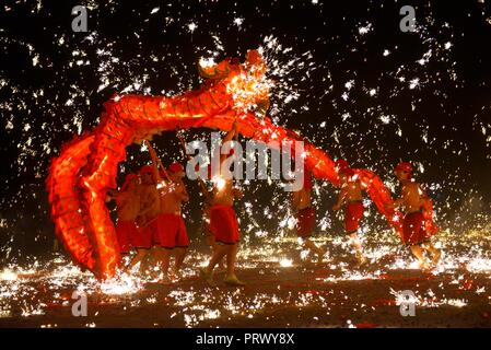 Puding, della Cina di Guizhou. 3° Ott, 2018. Artisti Folk eseguire un dragon dance in mezzo alle docce di ferro fuso in Xiushui villaggio di Longchang township di Puding County, a sud-ovest della Cina di Guizhou, Ottobre 3, 2018. Le persone in tutta la Cina ha aderito in diverse attività per il tempo libero durante il paese della durata di una settimana giornata nazionale di vacanza. Credito: Qin pista/Xinhua/Alamy Live News Foto Stock