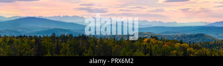 Ampio angolo di panorama autunno foresta,Misty Hills cime in rosa alba. Foto Stock