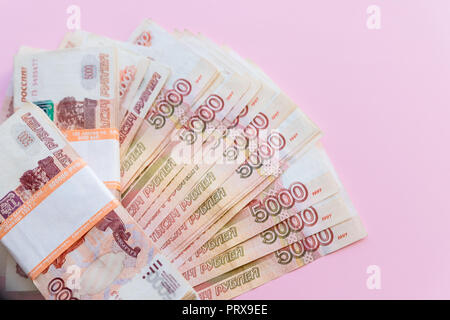 Il pacchetto di cinque millesimo ruble note in mezzo milione di rubli russi nel pacchetto bancario è sullo sfondo delle banconote sparse.finanziario e bancario.i concetti di spazio di copia Foto Stock
