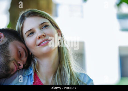 L'uomo la rilassante alle spalle della donna Foto Stock