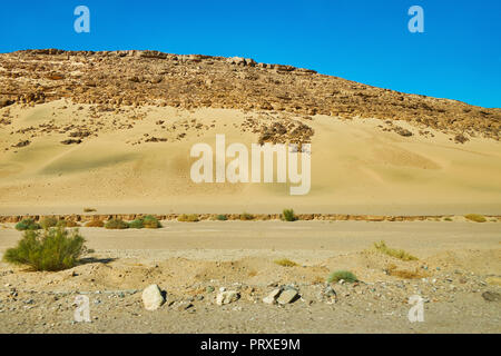 Il Rocky Hill nel deserto del Sinai con scenic giallo pendio di sabbia, Egitto. Foto Stock