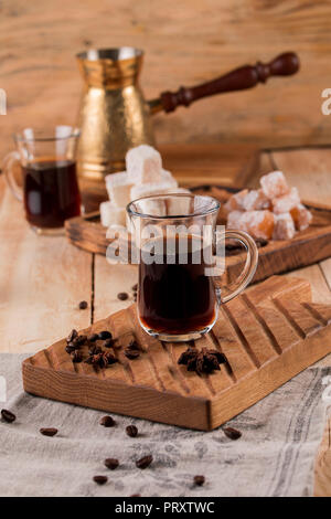 Caffè in chicchi, Turk, macinino da caffè su uno sfondo di legno. caffè turco nel tradizionale goffrato metallo turk. Foto Stock