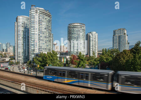 Lo Skytrain in movimento lungo le piste con la città di Vancouver come sfondo, Foto Stock