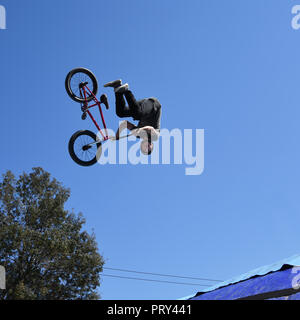 Giovane uomo freestyle stunt ciclista volare nel cielo con la sua moto effettuando un salto da skate-park rampa durante il Sofia Extreme Sports Festival Foto Stock