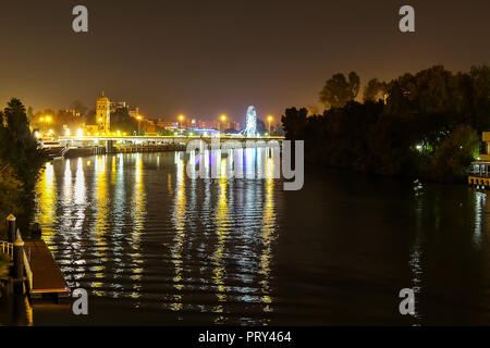 Vista notturna di Siviglia cityscape oltre il fiume Guadalquivir Foto Stock