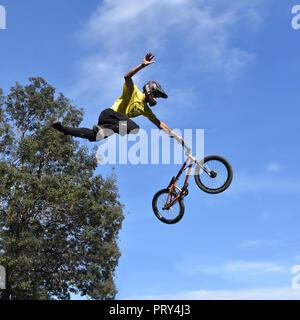 Ragazzo giovane freestyle stunt ciclista volare nel cielo con la sua moto effettuando un salto da skate-park rampa durante il Sofia Extreme Sports Festival Foto Stock