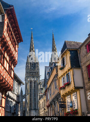 Quimper metà medievali con travi di legno vecchio e storico quartiere di shopping guglia della cattedrale in background Quimper Bretagna Francia Foto Stock