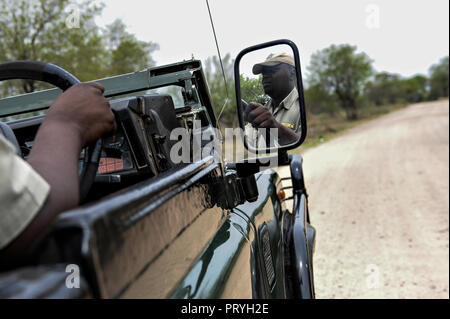 Un ranger in una jeep toyota su safariat Kapama Game Reserve safari, parco nazionale Kruger, Africa. La sua riflessione è in specchio Foto Stock