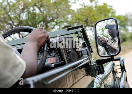 Un ranger in una jeep toyota su safariat Kapama Game Reserve safari, parco nazionale Kruger, Africa. La sua riflessione è in specchio Foto Stock