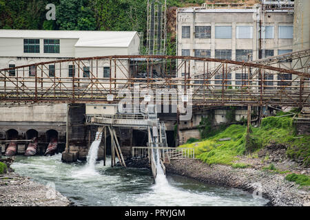 Abbandonato il vecchio falling apart rusty fabbrica sul fiume Willamette. A chiudere la vista di un ponte arrugginito. Segni leggi "ira, barche sono vietate". Foto Stock