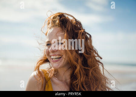 Ritratto di una donna redheaded, ridevano allegramente sulla spiaggia Foto Stock