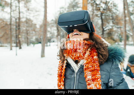 Donna che indossa occhiali per realtà virtuale nel paesaggio invernale Foto Stock