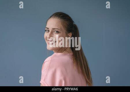 Ritratto di una donna graziosa, sorridente, guardando la fotocamera Foto Stock