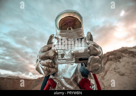 Spaceman esplorando il pianeta anonimi, analizzatore di contenimento Foto Stock