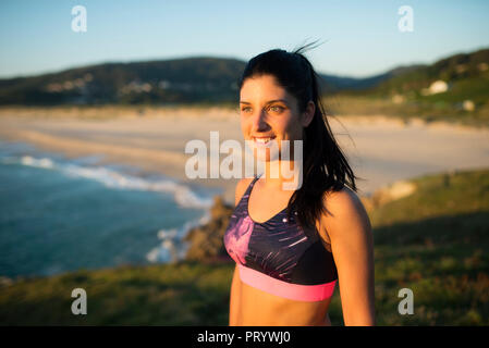 Ritratto di un atleta donna di sera, spiaggia in background Foto Stock