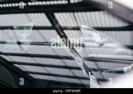 Imprenditore dietro la finestra auto Foto Stock