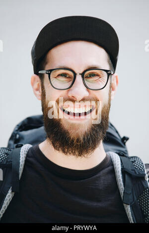 Ritratto di laughing man con zaino vestita di nero Foto Stock