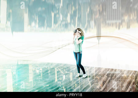 Stati Uniti d'America, New York City, giovane donna utilizzando occhiali per realtà virtuale, composito Foto Stock