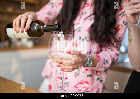 Close-up di donna versando il vino bianco in vetro Foto Stock