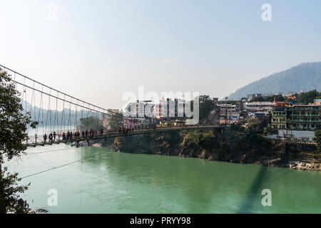 Una foto della Valle di Rishikesh dal Lakshman Jhula sospensione ferro ponte che attraversa il fiume Gange nella città santa di Rishikesh, India del Nord. Foto Stock